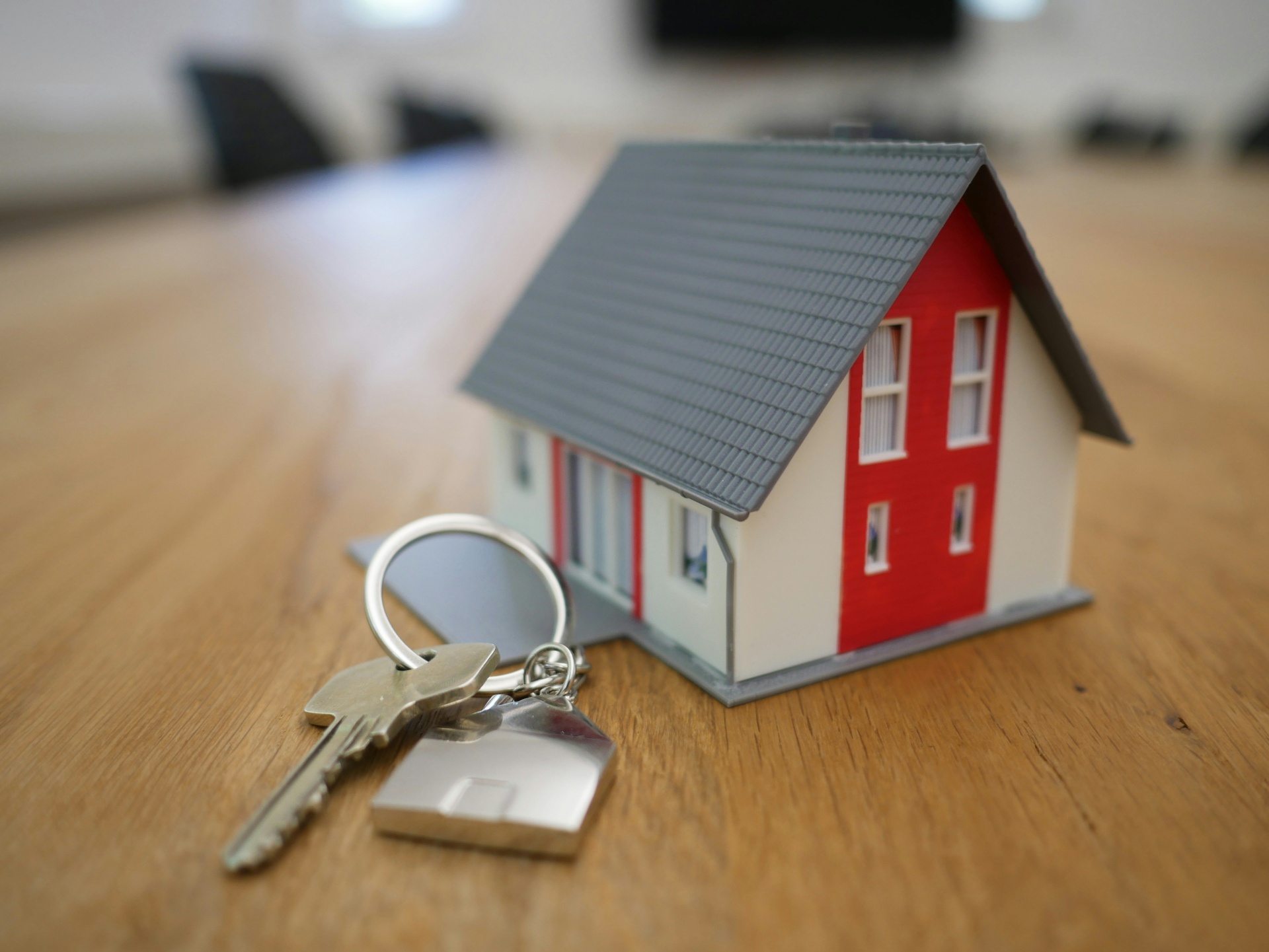 Llaves junto a una maqueta de casa, simbolizando la entrega de tu nueva vivienda