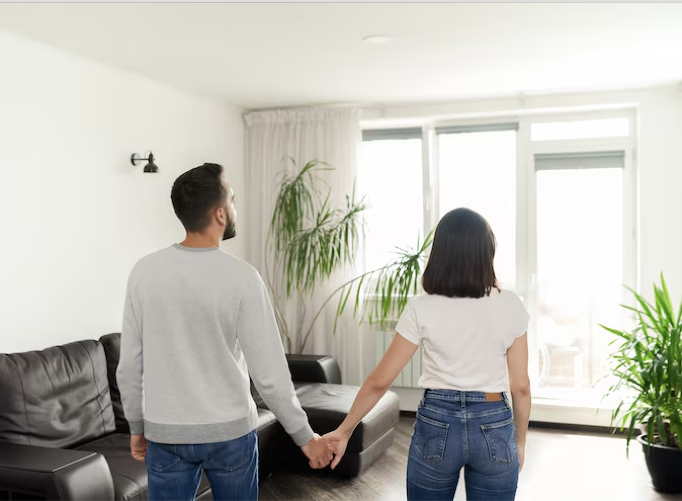 Pareja de la mano observando el salón de su nueva vivienda