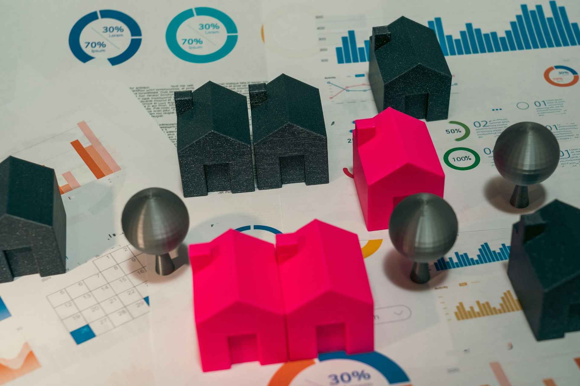 Maquetas de viviendas sobre gráficos financieros, simbolizando análisis hipotecario